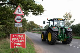 File photo dated 04/10/22 of a tractor passing a sign near Eccles in Norfolk, in an Avian Influenza Prevention Zone (AIPZ).