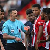 OFF AND ON: Referee Andrew Madley shows Sheffield United player Andre Brooks (right) a red card he later overturned after reviewing the pitchside monitor
