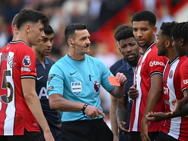 OFF AND ON: Referee Andrew Madley shows Sheffield United player Andre Brooks (right) a red card he later overturned after reviewing the pitchside monitor