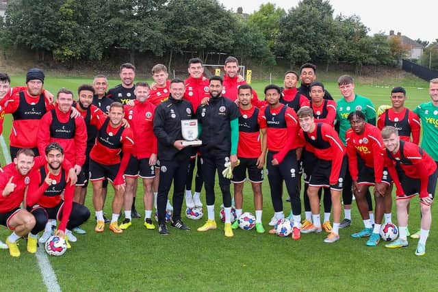 PRIDE OF PLACE: Wes Foderingham and Paul Heckingbottom hold the latter's manager of the month award for September in a crowded group photo