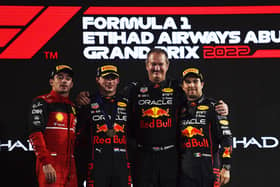 ABU DHABI, UNITED ARAB EMIRATES - NOVEMBER 20: Race winner Max Verstappen of the Netherlands and Oracle Red Bull Racing, second placed Charles Leclerc of Monaco and Ferrari, Olaf Janssen, Red Bull Racing Team Member and Third placed Sergio Perez of Mexico and Oracle Red Bull Racing celebrate on the podium during the F1 Grand Prix of Abu Dhabi at Yas Marina Circuit on November 20, 2022 in Abu Dhabi, United Arab Emirates. (Photo by Rudy Carezzevoli/Getty Images)