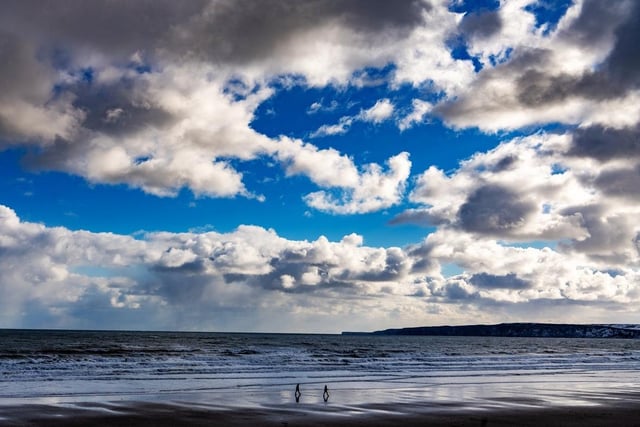 Members of the public going for a socially distanced walk on Filey beach at the height of the pandemic. This beach has a rating of four and a half stars on TripAdvisor with 2,571 reviews.