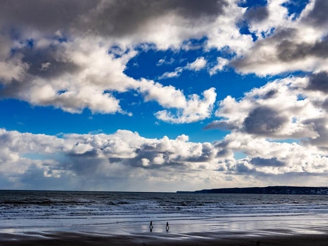Members of the public going for a socially distanced walk on Filey beach at the height of the pandemic. This beach has a rating of four and a half stars on TripAdvisor with 2,571 reviews.