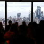 Guests gather in front of a window with view on the City financial district of London as they attend the Western Balkans Investment Summit 2024 at the EBRD headquarters in London on February 26, 2024. (Photo by HENRY NICHOLLS / AFP)