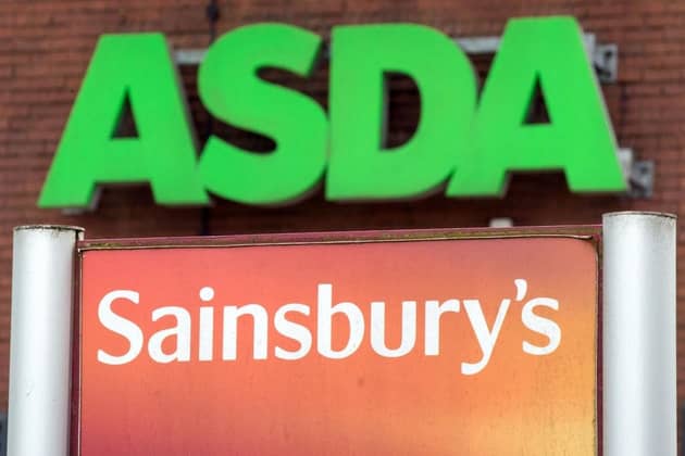 Logos of supermarket chains Asda and Sainsbury's. (Pic credit: Oli Scarff / AFP via Getty Images)