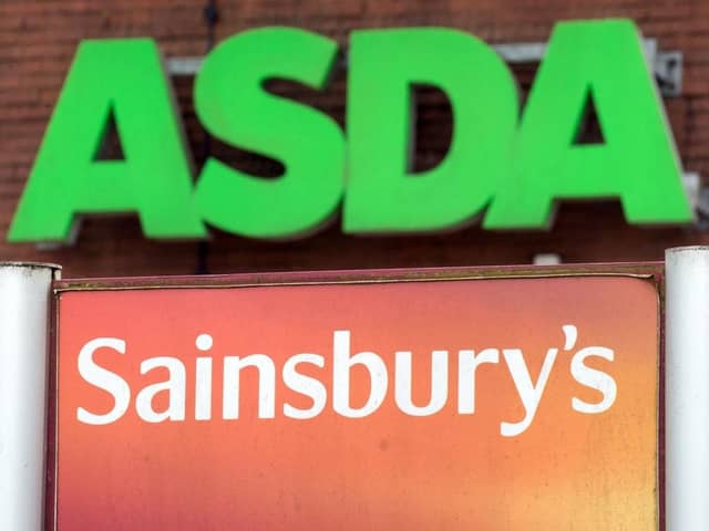 Logos of supermarket chains Asda and Sainsbury's. (Pic credit: Oli Scarff / AFP via Getty Images)