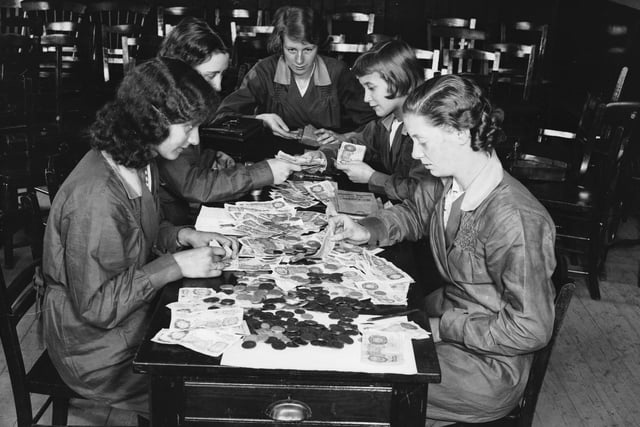 25th September 1936:  Students at a Sheffield commercial college learn to count money using ?200 worth of real notes and coins.  (Photo by Nick Yapp/Fox Photos/Getty Images)