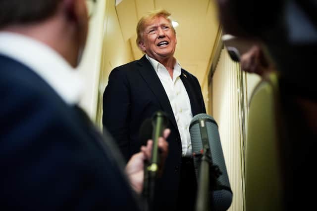 President Donald Trump speaks with reporters while in flight on Air Force One. PIC: AP Photo/Julia Demaree Nikhinson