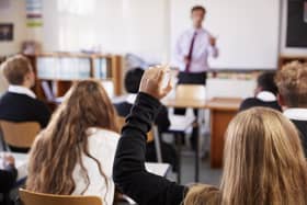 ADOBE STOCKFemale Student Raising Hand To Ask Question In Classroom