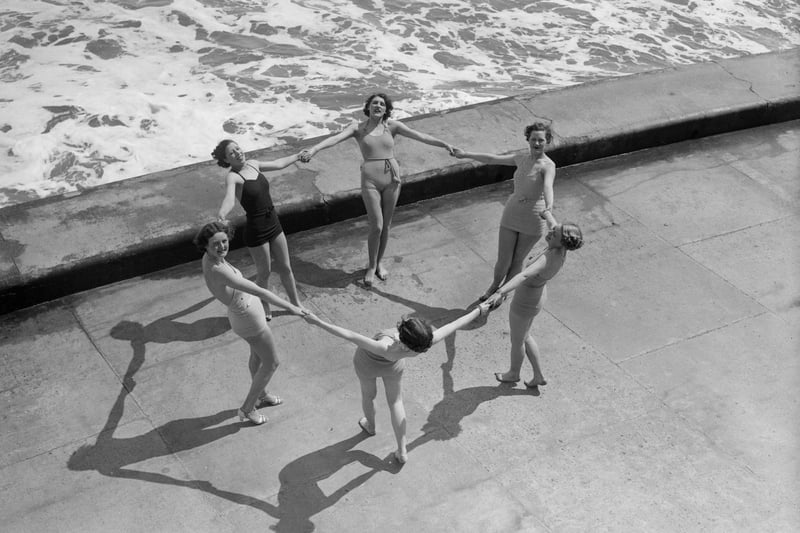 June 1936:  Bathing belles form a circle on the water's edge at Scarborough.