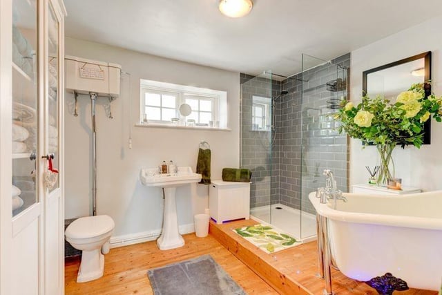 This bathroom suite includes a roll top bath and a walk-in shower