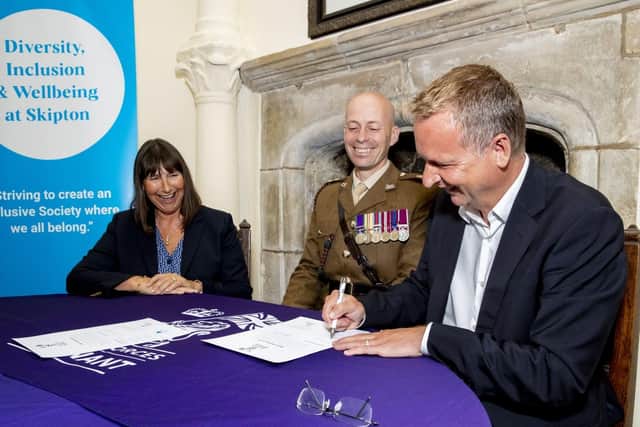 Skipton Group CEO Stuart Haire, Skipton Building Society chair Gwyn Burr and Lieutenant Colonel Richard Hill signing the Armed Forces Covenant at Skipton Castle.