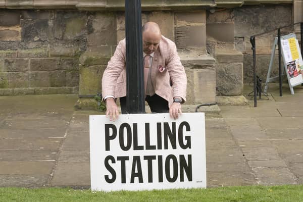 A polling station sign is adjusted oustide the polling station in Bridlington Priory Church, Yorkshire. PIC: Danny Lawson/PA Wire