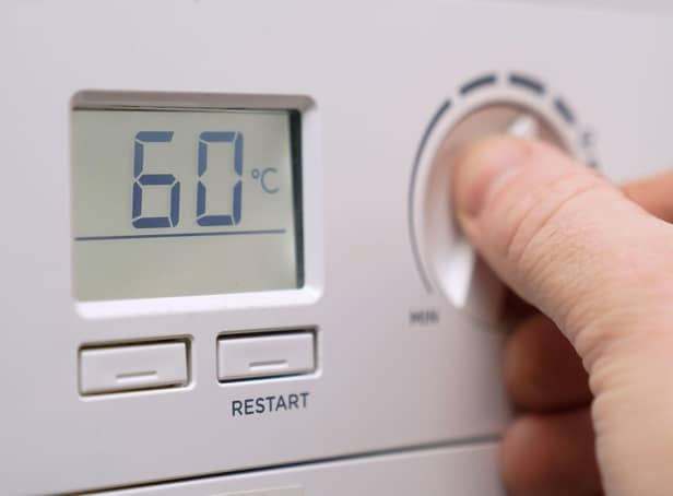 A homeowner turning down the temperature of a gas boiler. Photo: Andrew Matthews/PA Wire
