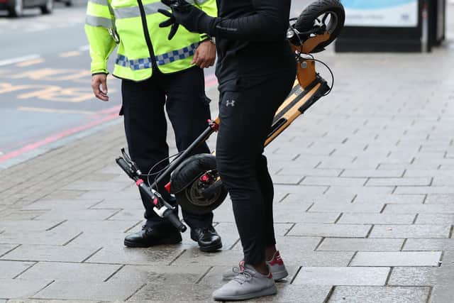 File photo dated 26/07/19 of an e-scooter rider being stopped by a police officer