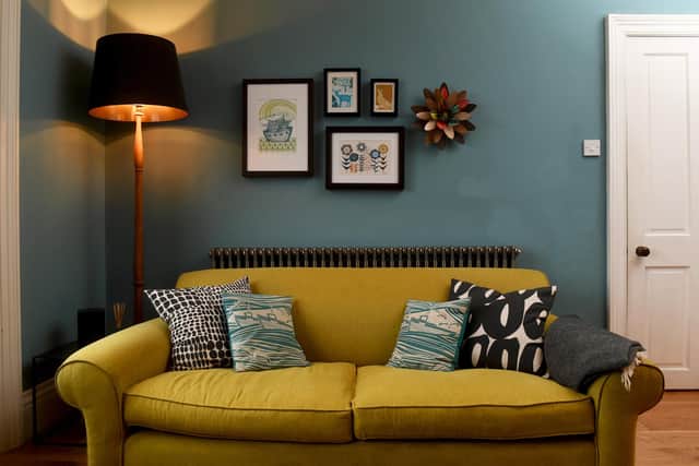 The sitting room with a reupholsered sofa, cushions from Mini Moderns and prints bought from favourite artists