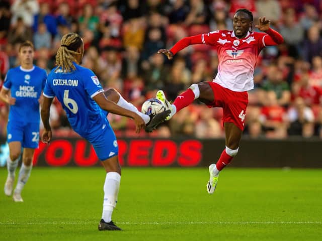 Barnsley's Devante Cole challenges Peterborough United's Romoney Critchlow in the League One game at Oakwell in August. Picture: Bruce Rollinson.
