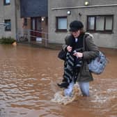 A resident walks through a flooded street in Brechin, northeast Scotland, on October 20, 2023 as Storm Babet batters the country. (Photo by ANDY BUCHANAN / AFP) (Photo by ANDY BUCHANAN/AFP via Getty Images)