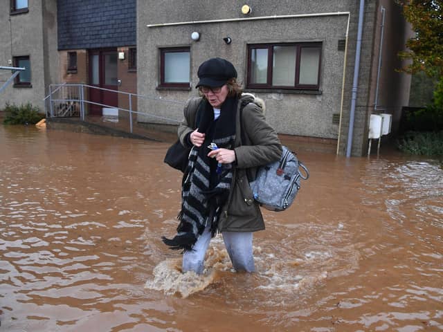 A resident walks through a flooded street in Brechin, northeast Scotland, on October 20, 2023 as Storm Babet batters the country. (Photo by ANDY BUCHANAN / AFP) (Photo by ANDY BUCHANAN/AFP via Getty Images)
