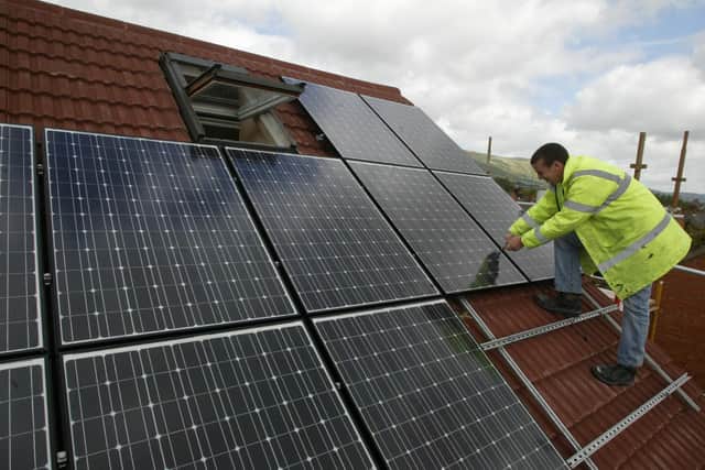 Solar panels being installed on a buildings roof. PIC: Niall Carson/PA Wire