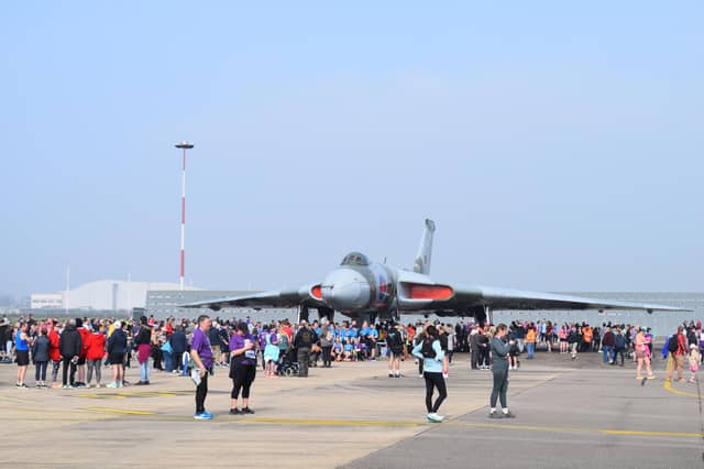 Runners taking part in the Run The Runway event with the Vulcan XH558 bomber in the background