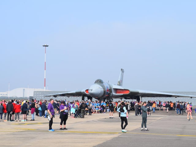 Runners taking part in the Run The Runway event with the Vulcan XH558 bomber in the background