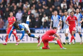 FLYING IN: Huddersfield Town's David Kasumu (left) takes a tumble after Tyler Morton's tackle
