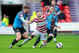 Doncaster Rovers' striker Caolan Lavery falls under pressure from Northampton's Jack Sowerby. Picture: Bruce Rollinson