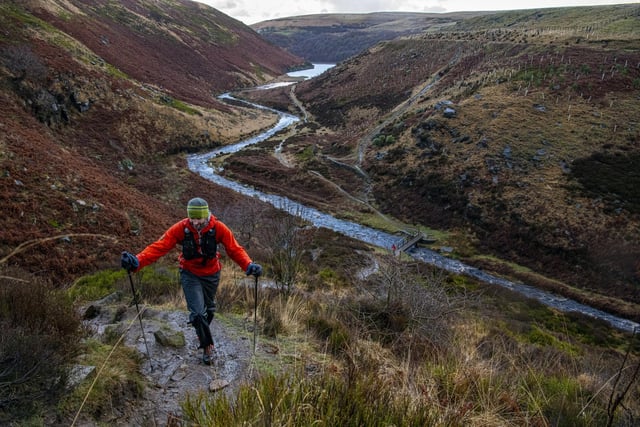 A competitor scrambles uphill on the Pennine Way close to Blakeley Reservoir near Meltham, West Yorkshire as they take part in the Spine Race.