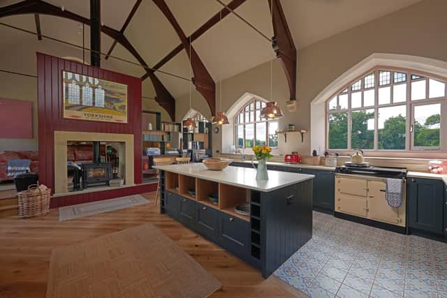 The kitchen cabinetry and island are by Watsons of Harrogate designed in a heritage style and the lights over the island are made from colanders.