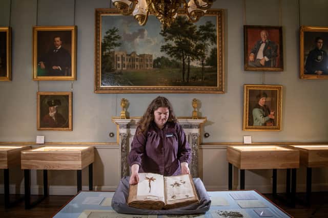 Curator Sarah Burton with an eighteenth century volume of pressed plant specimens featuring in the exhibition The Curiosity Garden. Photograph by Tony Johnson.