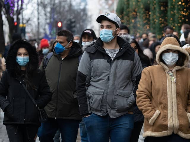 Shoppers, some wearing masks to combat the spread of Covid-19, queue to enter Selfridges department store ahead of their Boxing Day sale in central London on December 26, 2021. (Photo by Niklas HALLE'N / AFP) (Photo by NIKLAS HALLE'N/AFP via Getty Images)