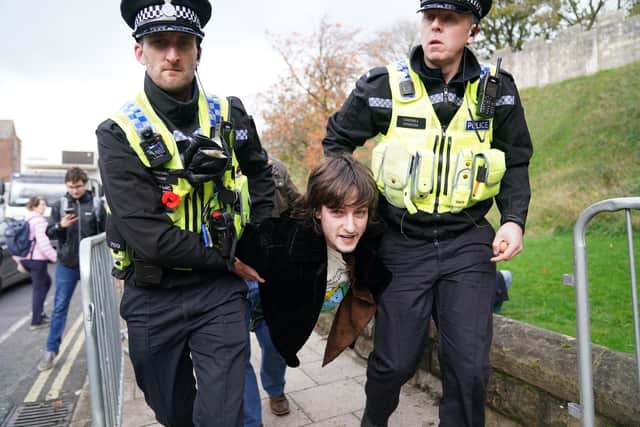 Police detain a protester after he appeared to throw eggs at King Charles III and the Queen Consort as they arrived for a ceremony at Micklegate Bar in York,