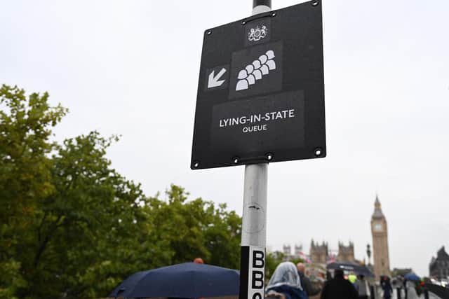 A sign directs members of the public to the queue for Westminster Hall, where Queen Elizabeth II will Lie In State, opposite the Palace of Westminster, the Houses of Parliament, in London on September 13, 2022. (Photo by Alain JOCARD / AFP) (Photo by ALAIN JOCARD/AFP via Getty Images)