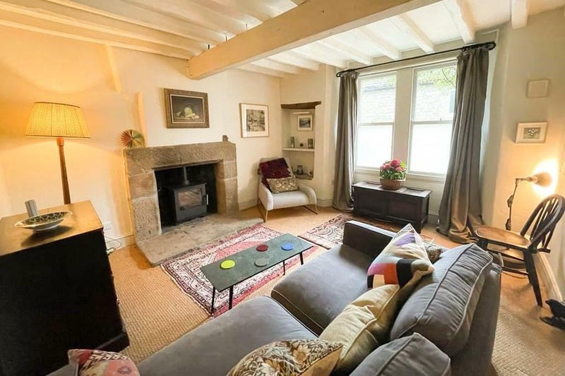 The cosy sitting room is warmed by a wood-burning stove