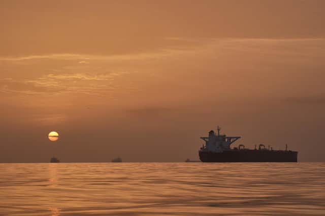 The sun rises behind tankers anchored in the Strait of Hormuz off the coast of Qeshm Island, Iran, Saturday, April 18, 2026. (AP Photo/Asghar Besharati)