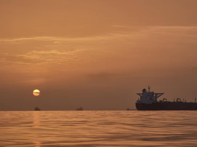 The sun rises behind tankers anchored in the Strait of Hormuz off the coast of Qeshm Island, Iran, Saturday, April 18, 2026. (AP Photo/Asghar Besharati)