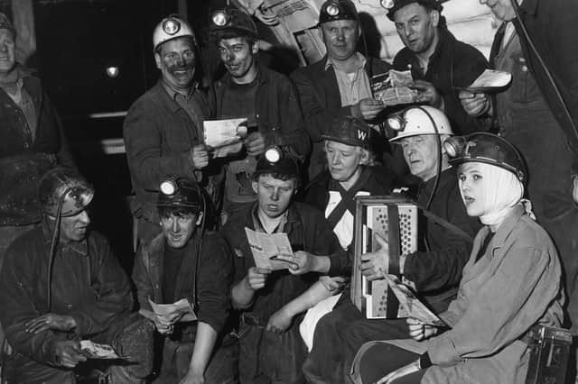 Miners at Wath Main Colliery singing Christmas carols 550 ft underground with women nurses from the colliery first aid post.