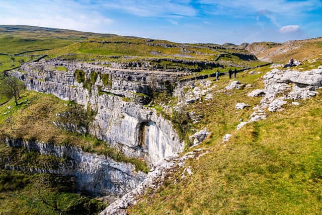 PicturePost - Malham Cove a beauty spot in the Yorkshire Dales National Park, a place of natural beauty, geological wonder, and unbeatable views. Malham Cove is a large curved limestone formation north of the village of Malham, formed by a waterfall carrying meltwater from glaciers at the end of the last Ice Age more than 12,000 years ago. Over 70 metres high an absolute favourite for walkers or travellers. A footpath stretches from the edge of the village along the valley winding it's way towards the breathtaking Malham Cove, before the climb up the stone steps to the top where Limestone pavement at the top of the cove was used as a filming location for Harry Potter and the Deathly Hallows. Picture: James Hardisty. Date: 8th April 2026.