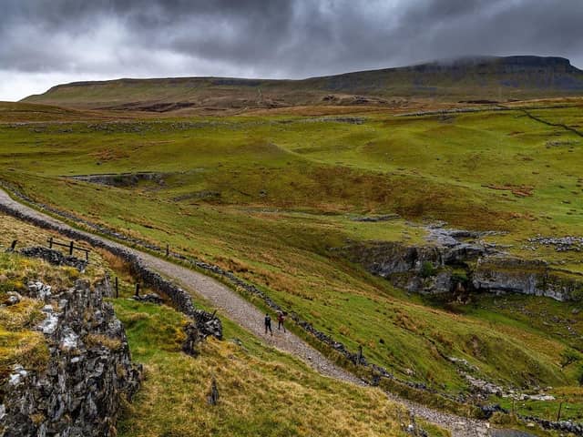 Two walkers make their way along a stone track after leaving the comfort of  Horton-in-Ribblesdale, near Settle. (Pic credit: James Hardisty)