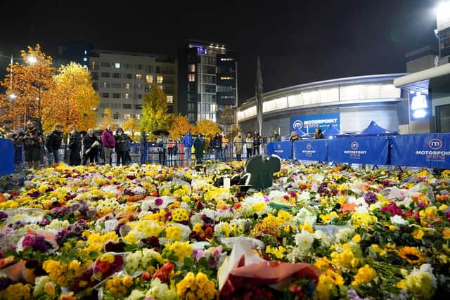 Fans look at floral tributes outside the Motorpoint Arena, Nottingham, ahead of a memorial for Nottingham Panthers' ice hockey player Adam Johnson. Adam Johnson died after an accident during a Challenge Cup match with Sheffield Steelers last Saturday. (Picture: Zac Goodwin/PA Wire)