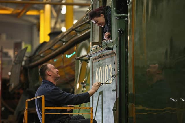 YORK: Heritage painter Mike O'Connor paints engine number 60103 onto the side of the Flying Scotsmans cab in 2016 (Photo by Christopher Furlong/Getty Images)