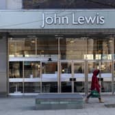 A woman walks past the now closed John Lewis store in Sheffield