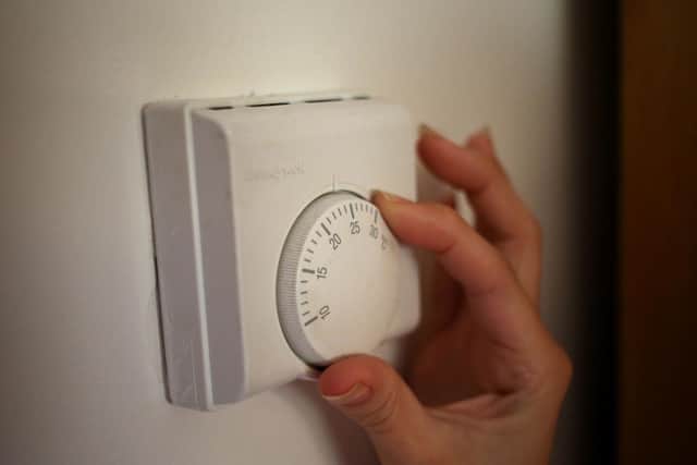 A person using a central heating thermostat. Pic: Steve Parsons/PA Wire