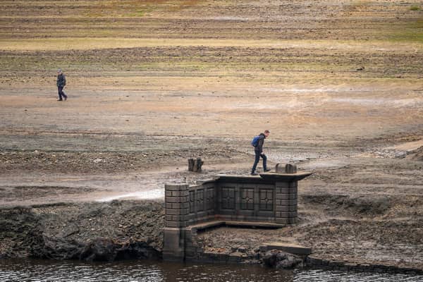 People inspect the ruins of Derwent Village, flooded in the 1940s to provide drinking water for the East Midlands and Sheffield, become exposed due to the low water level at Ladybower Reservoir and drought conditions. (Photo by Christopher Furlong/Getty Images)