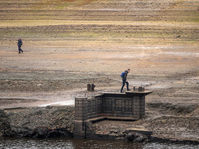 People inspect the ruins of Derwent Village, flooded in the 1940s to provide drinking water for the East Midlands and Sheffield, become exposed due to the low water level at Ladybower Reservoir and drought conditions. (Photo by Christopher Furlong/Getty Images)