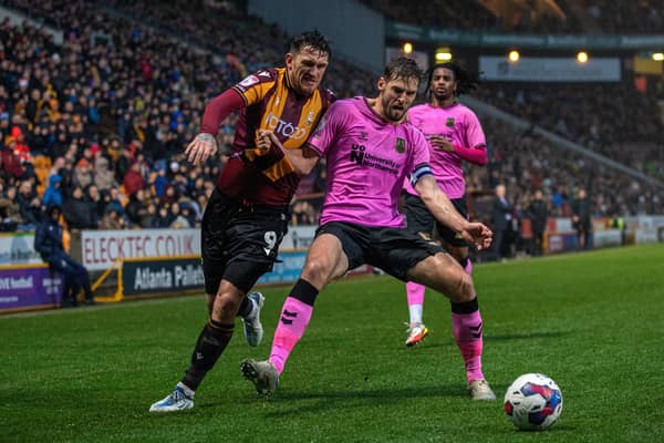Bradford City's Andy Cook is held off the ball by Northampton captain Jon Guthrie. Picture: Bruce Rollinson