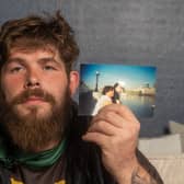 Josh Cook holds a photograph of himself and his mum, Lisa, when he was young