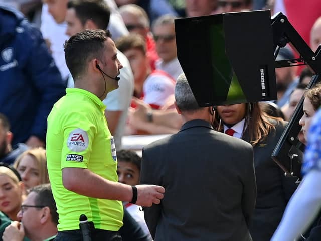 CONTROVERSIAL: Chris Kavanagh consults the pitch-side monitor after a VAR (Video Assistant Referee) review before sending off Leeds United's Luke Ayling