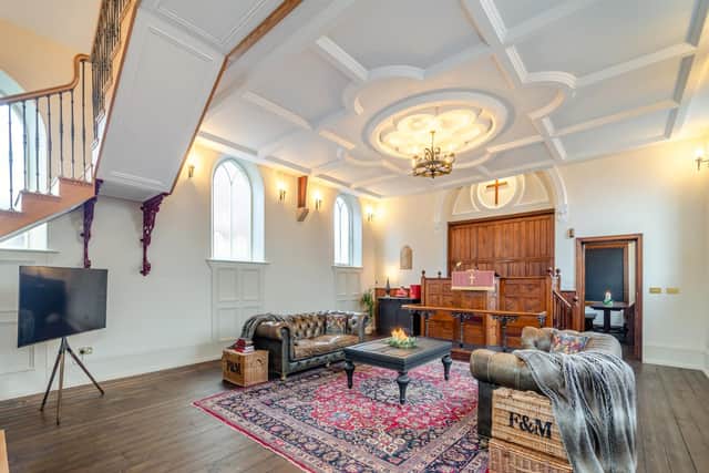 The sitting area with the orignal church altar, sensational decorative plaster ceiling and cantilvered staircase leading to the mezzanine level
